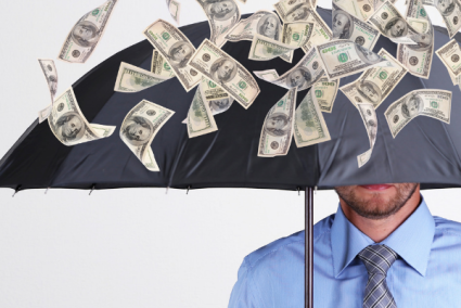 A man standing under an umbrella with money raining down